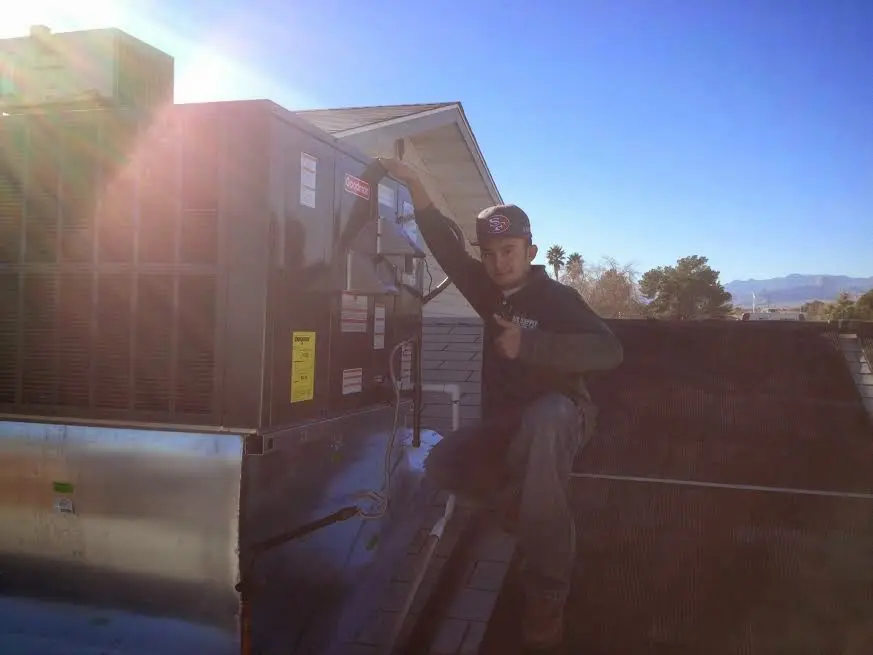 HVAC technician performing Heat Pump Repair on a rooftop unit in Sulphur